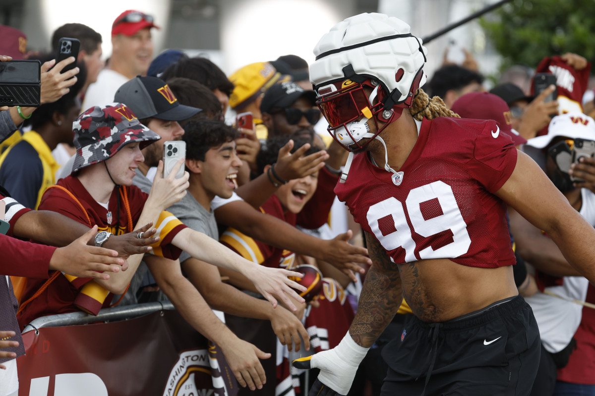 Washington Commanders defensive end Chase Young (99) shakes hands with fans while walking to the fields prior to day two of Commanders training camp at OrthoVirginia Training Center.